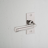 Digby gefederter Türgriff, kurzes Schild in poliertem Nickel mit rechteckigem Rückschild und weißer Wand.