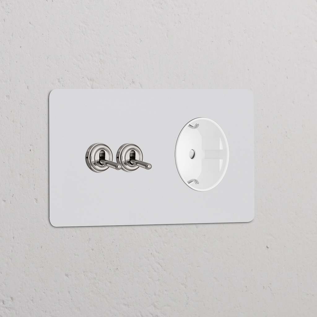 Zweifachrahmen mit 2 Kipphebelschaltern und Schuko-Typ-F-Steckdose, lackierbar in poliertem Nickel-Finish für die Wandmontage.