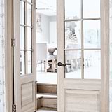 Manilla para puertas Digby fija con muelle en bronce en una habitación blanca