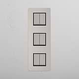 Interruptor para control de la luz de súper capacidad en diseño vertical: Interruptor triple de balancín x6 en níquel pulido y negro vertical sobre fondo blanco