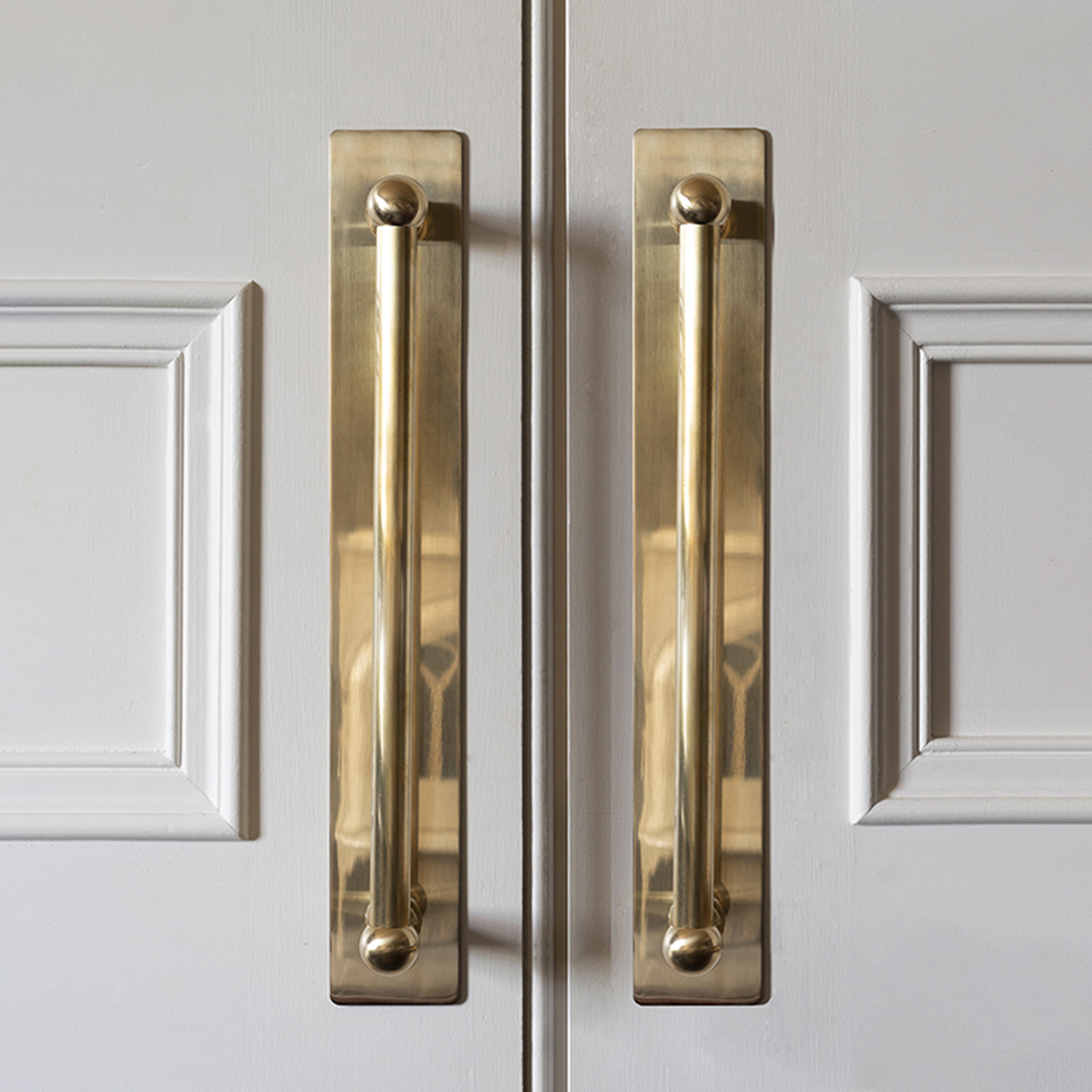 Tirador doble Harper con placa de 320 mm en latón antiguo para puertas medianas, con acabado dorado.