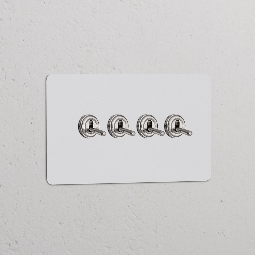 Interruptor de palanca x4 en marco doble, acabado en níquel pulido y pintable para ajustar a la pared blanca.