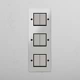 Interruptor triple de balancín en níquel pulido y traslúcido con negro en diseño vertical con seis posiciones - Solución avanzada para iluminación multifunción, sobre fondo blanco