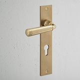 Manilla para puertas Digby con placa larga (con muelle) y cerradura europea - Latón antiguo
