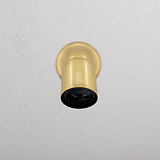 Lámpara empotrada Ealing en latón antiguo, montada en techo blanco, ideal para iluminación exterior elegante.