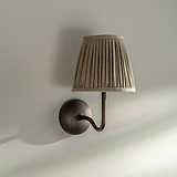 Aplique de pared Malvern mediano en beige natural colocado en ángulo sobre una pared