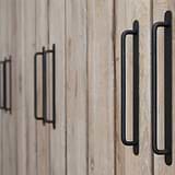 Tirador Kilburn para muebles en bronce sobre despensas de madera