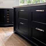 Tirador Kilburn para muebles en níquel pulido sobre despensa negra