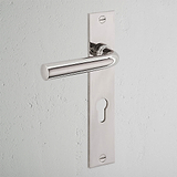Manilla para puertas Apsley con placa larga en níquel pulido con cerradura europea sobre puerta blanca.