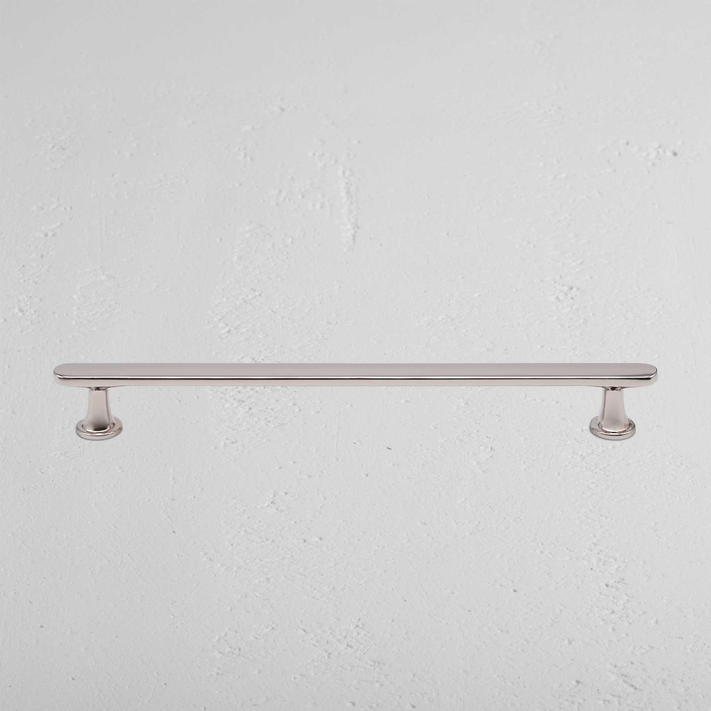 Tirador estilo manija para muebles Milliner en níquel pulido sobre fondo blanco