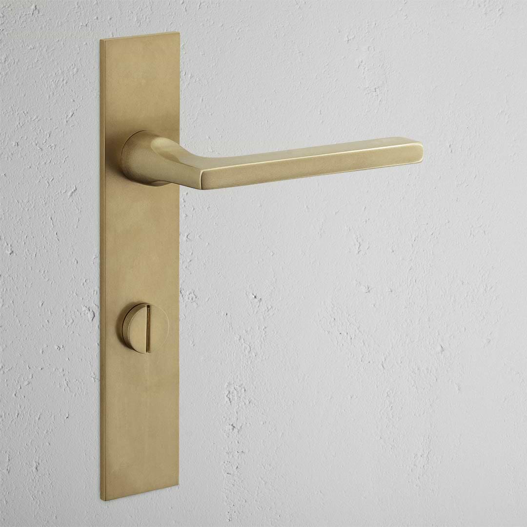 Manilla para puertas Clayton con placa larga (con muelle) y sistema giratorio - Latón antiguo