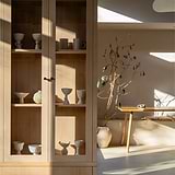Tirador redondo para muebles Bayswater - Bronce montado en un mueble de madera en una habitación minimalista.