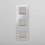 Interruptor triple de balancín en níquel pulido y traslúcido con blanco en diseño vertical - Sistema de control de iluminación para ahorrar espacio, sobre fondo blanco