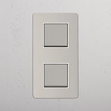 Interruptor doble vertical para control de la luz: Interruptor doble de balancín x2 en níquel pulido y blanco con diseño vertical sobre fondo blanco