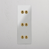 Interruptor triple de palanca en latón antiguo y traslúcido con seis palancas, diseño vertical - Accesorio elegante para iluminación, sobre fondo blanco