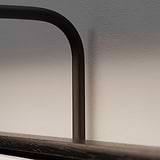 Primer plano de un marco negro con sombras sobre una pared blanca, iluminado por focos Harrow de 220 mm. 