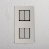 Interruptor de alta capacidad vertical para control de la luz: Interruptor doble de balancín x4 en níquel pulido y blanco con diseño vertical sobre fondo blanco
