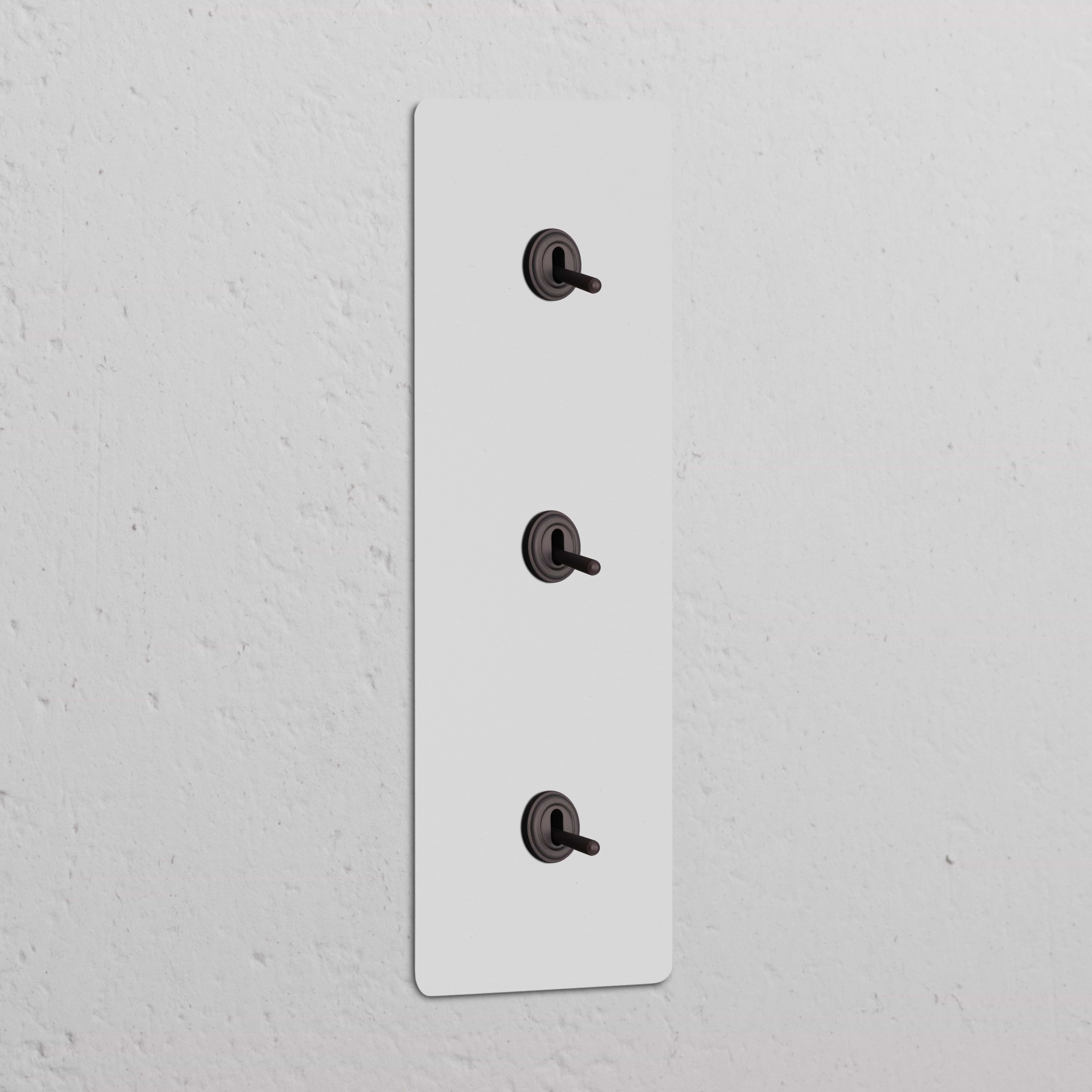 Interruptor conmutador de palanca x3 vertical (marco triple), pintable y bronce, para control de luces.