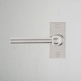 Manija de puerta Harper níquel pulido con placa corta y resorte, agrega elegancia a cualquier entrada.