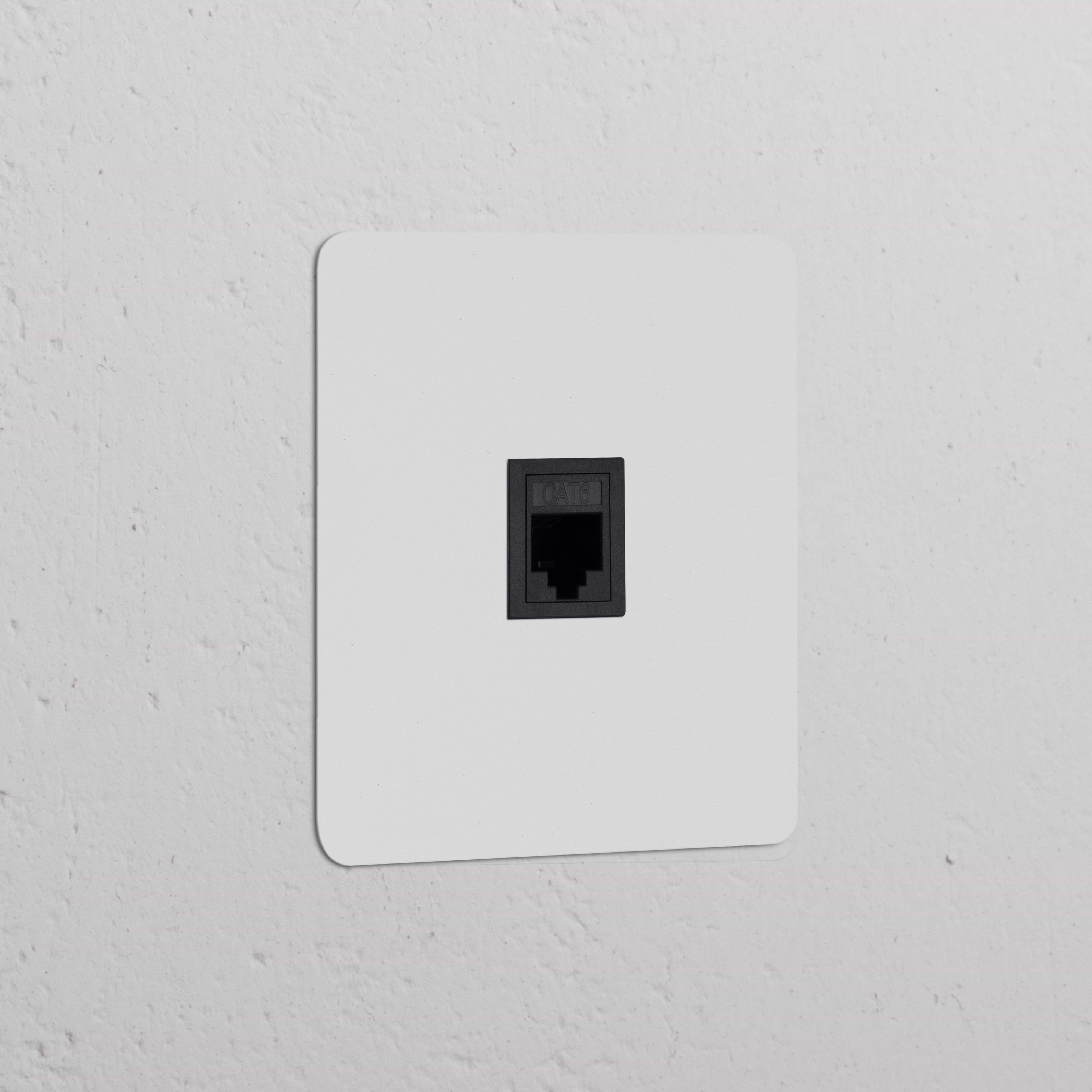 Prise RJ45 (Plaque Simple) - Insert noir, panneau de connexion Ethernet monté sur un mur blanc.