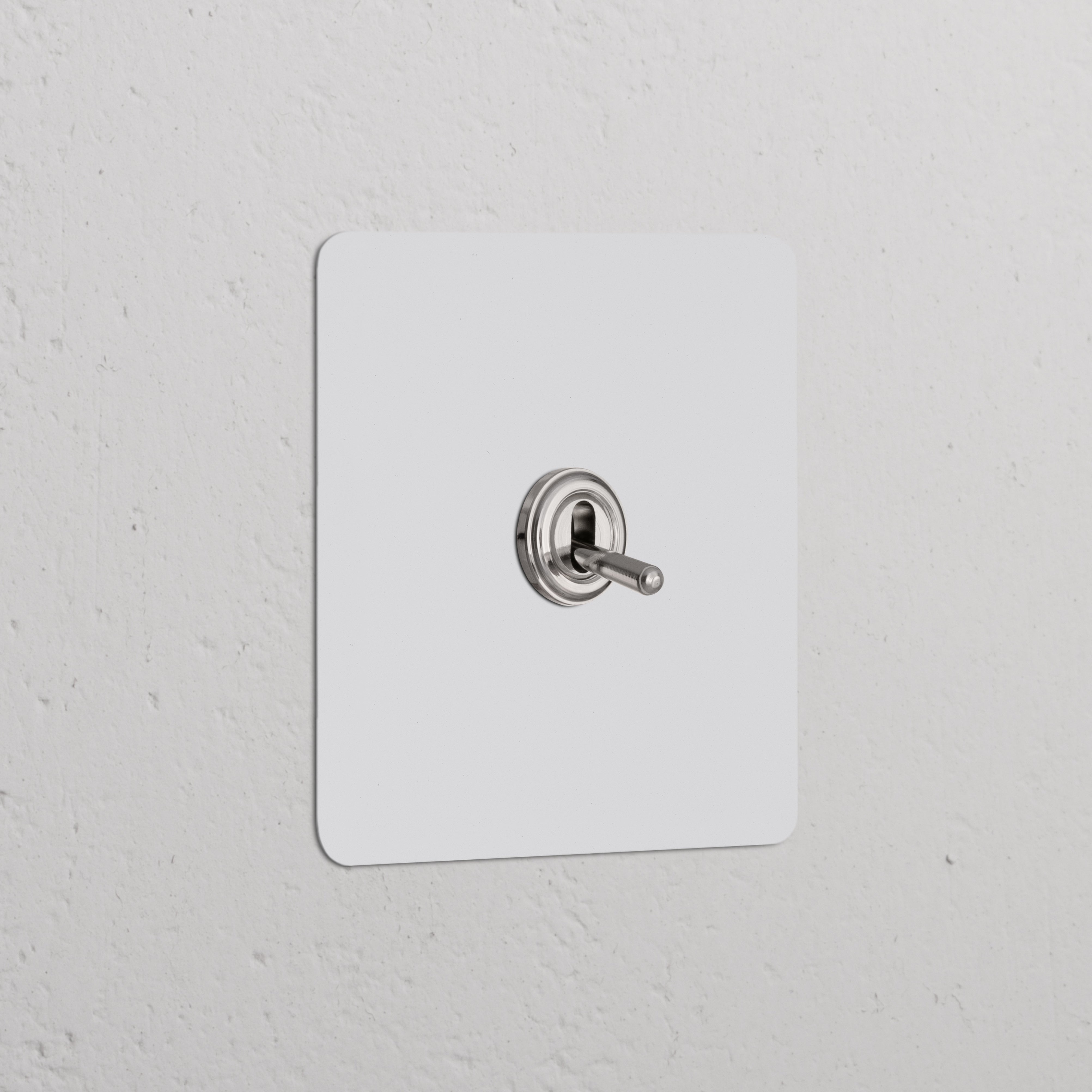 Permutateur à levier en nickel poli peignable, plaque simple, monté sur un mur blanc. Interrupteurs et variateurs simples.