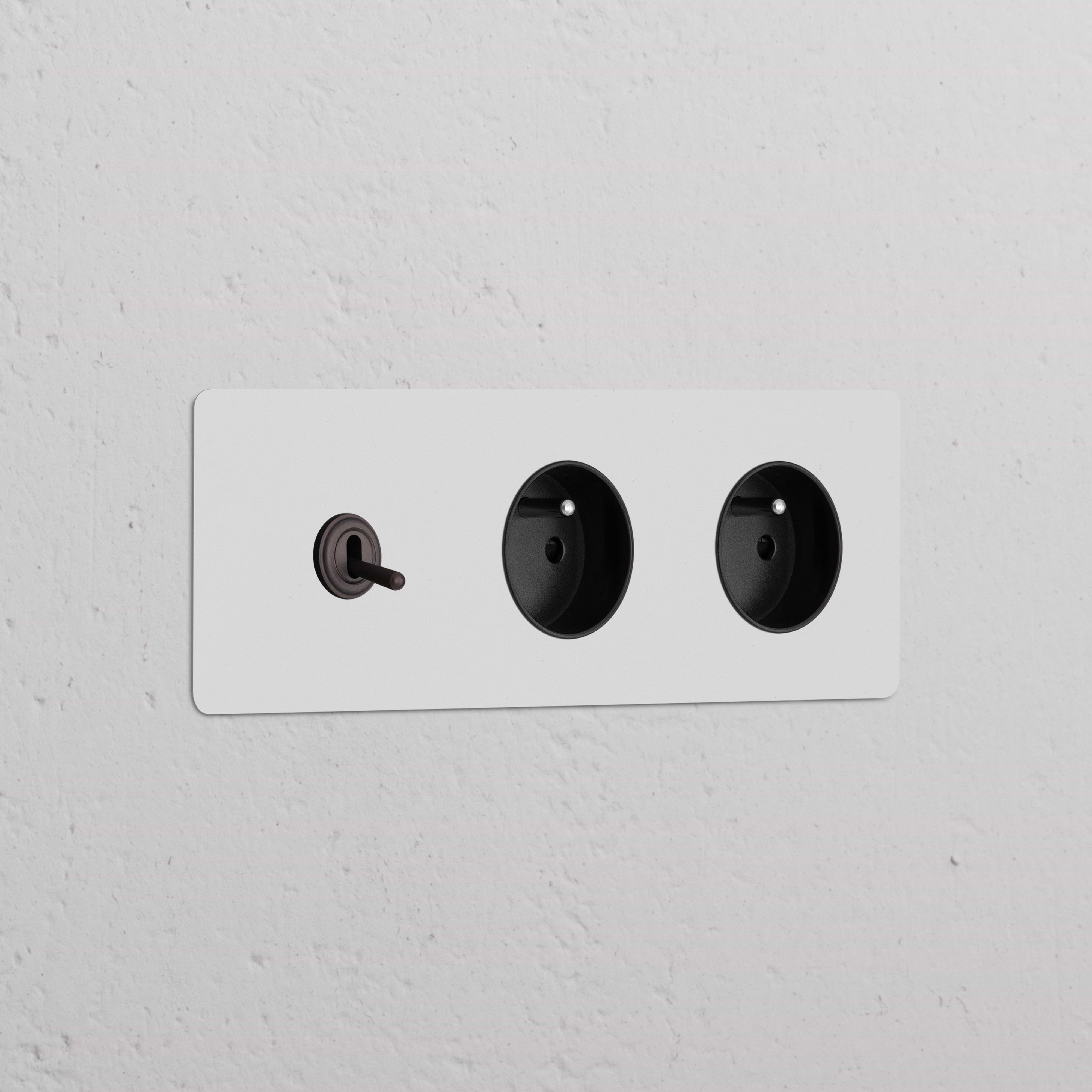Plaque double en bronze avec un Interrupteur VV à Levier et deux prises Type E, insert noir. Prises & Modules Triple.