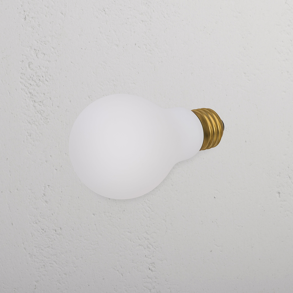 Ampoule LED Mulberry 12W E27 montée latéralement sur un mur blanc, émettant une lumière douce.