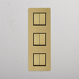 Six Position Triple Vertical Rocker Switch in Antique Brass Black on White Background