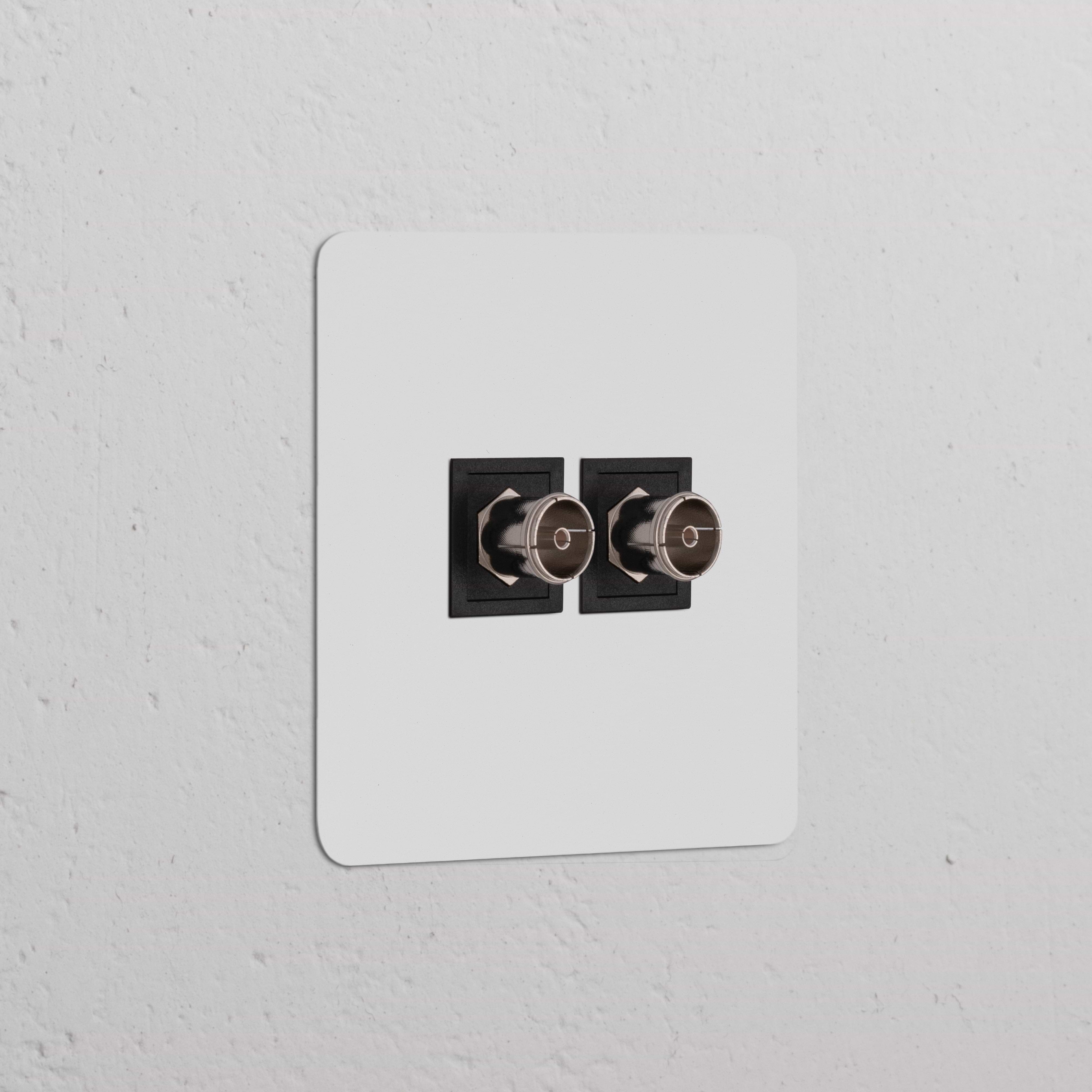 Prise TV x2 (Plaque Simple) en finition Peignable Noir sur panneau blanc, conçue pour les branchements télévisuels modernes.