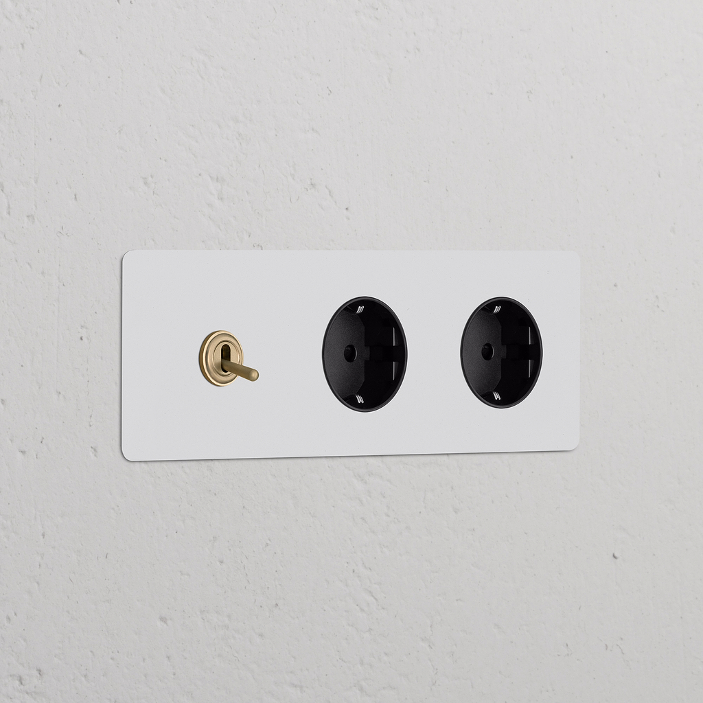 Triplo interruttore a levetta con 2 moduli Schuko, finitura in ottone antico nero verniciabile.