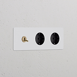 Triplo interruttore a levetta con 2 moduli Schuko, finitura in ottone antico nero verniciabile.