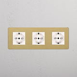 Prese triple Schuko/Bipasso su un pannello a parete in ottone bianco anticato, caratterizzato dal design Modulo Triplo 3x.