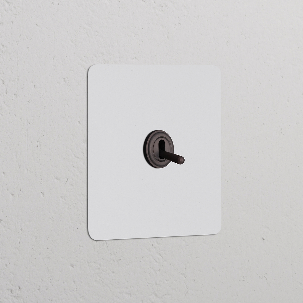 Invertitore a Levetta Singolo – Pitturabile Bronzo su placca murale; elegante interruttore a levetta singola, facile da integrare.