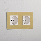 Presa elettrica doppia, Modulo Doppio 2x Schuko/Bipasso, con finitura ottone bianco anticato su telaio beige.