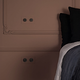 Interruttore Dimmer Doppio 2x in pitturabile bronzo su parete beige, offre un controllo dell'illuminazione personalizzabile.