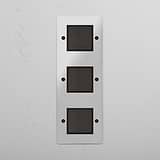 Interruttore bilanciere verticale triplo efficiente in bronzo trasparente nero: controllo illuminazione su sfondo bianco.