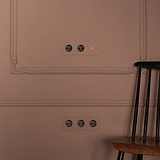 Triplo interruttore a levetta + 2x modulo Schuko tipo F in ottone antico nero su una parete elegante.
