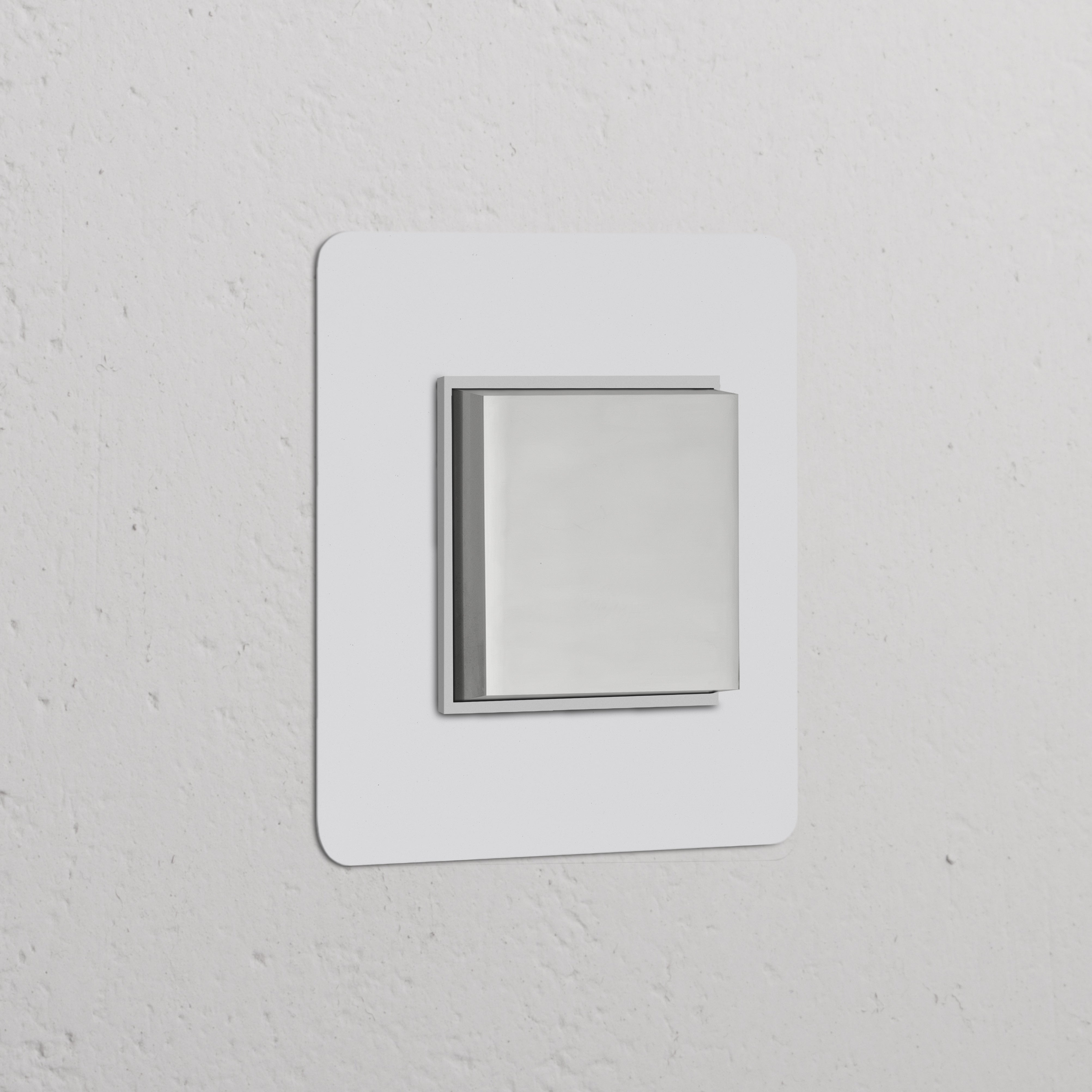 Polerowany niklowany przełącznik ścienny w pojedynczej ramce z białym, malowanym środkiem, minimalistyczny design.