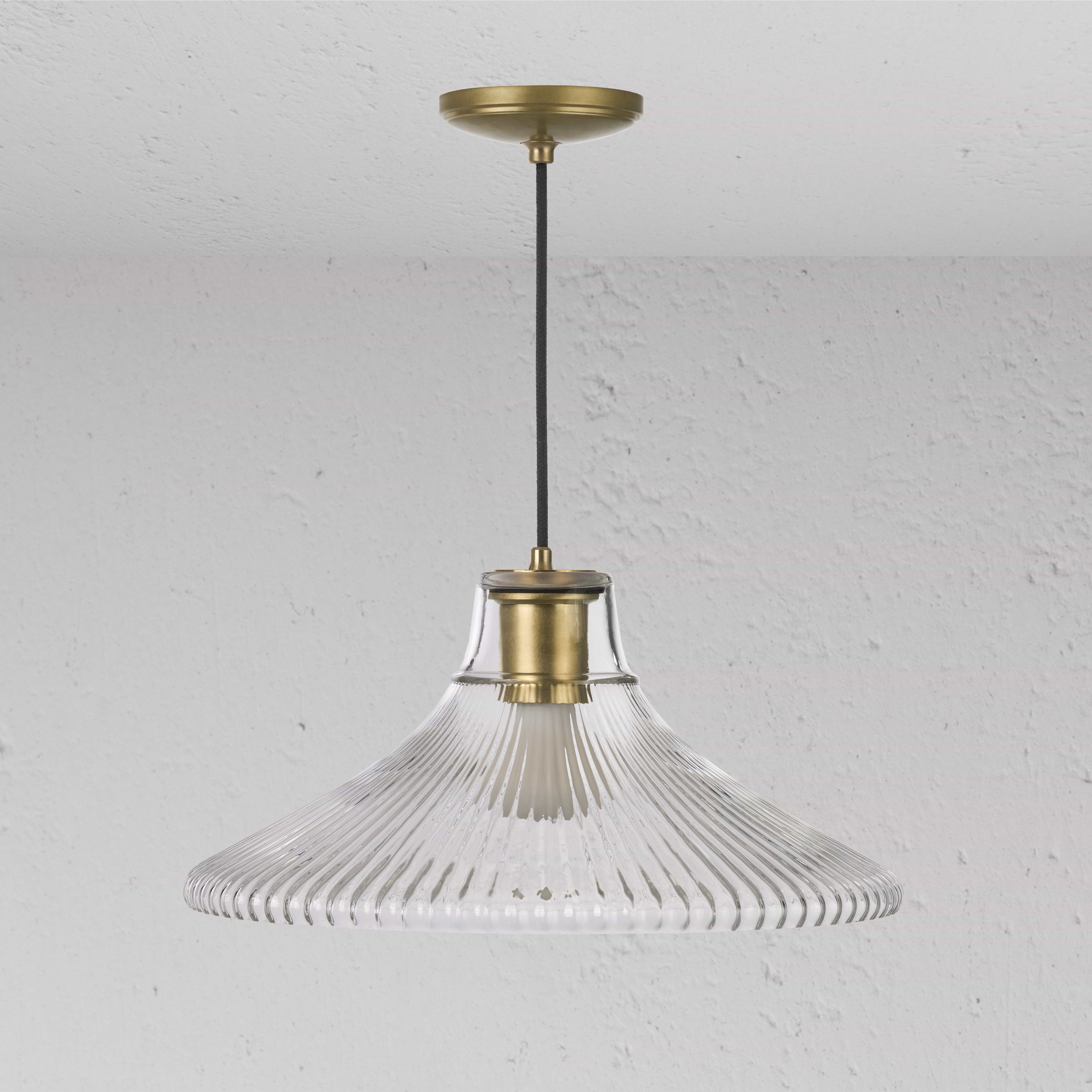 Duża lampa wisząca Hammersmith z żebrowanym szkłem i wykończeniem w kolorze starego mosiądzu, zawieszona na czarnym kablu.
