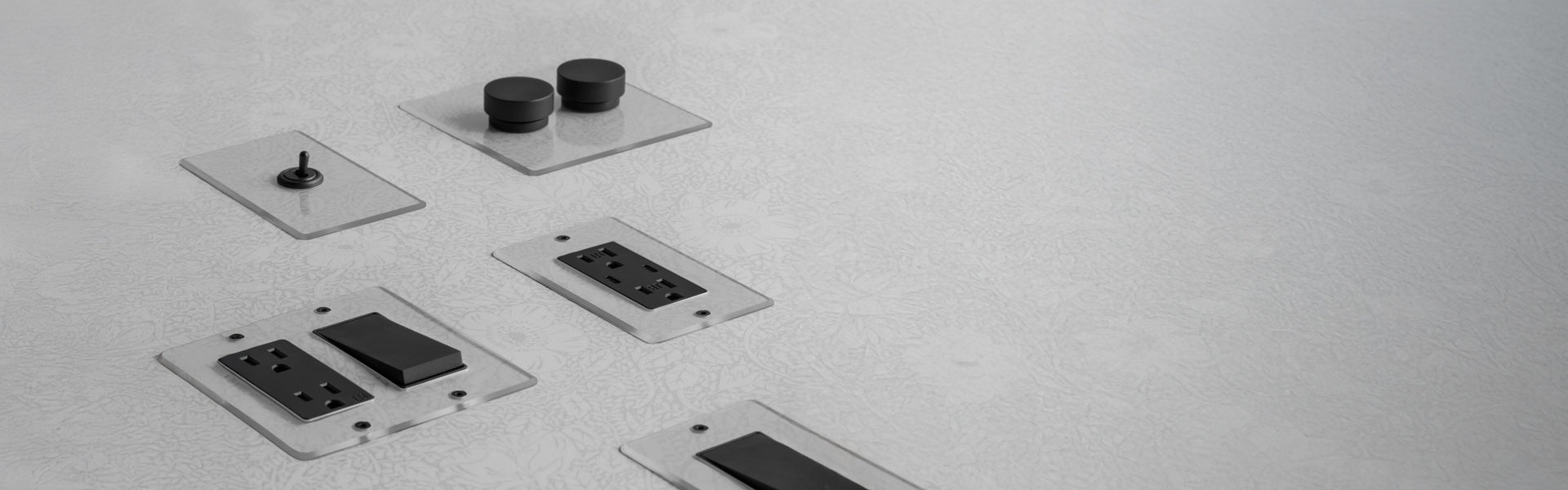 A minimalistic layout of various black electronic buttons and switches on transparent panels against a light gray background.