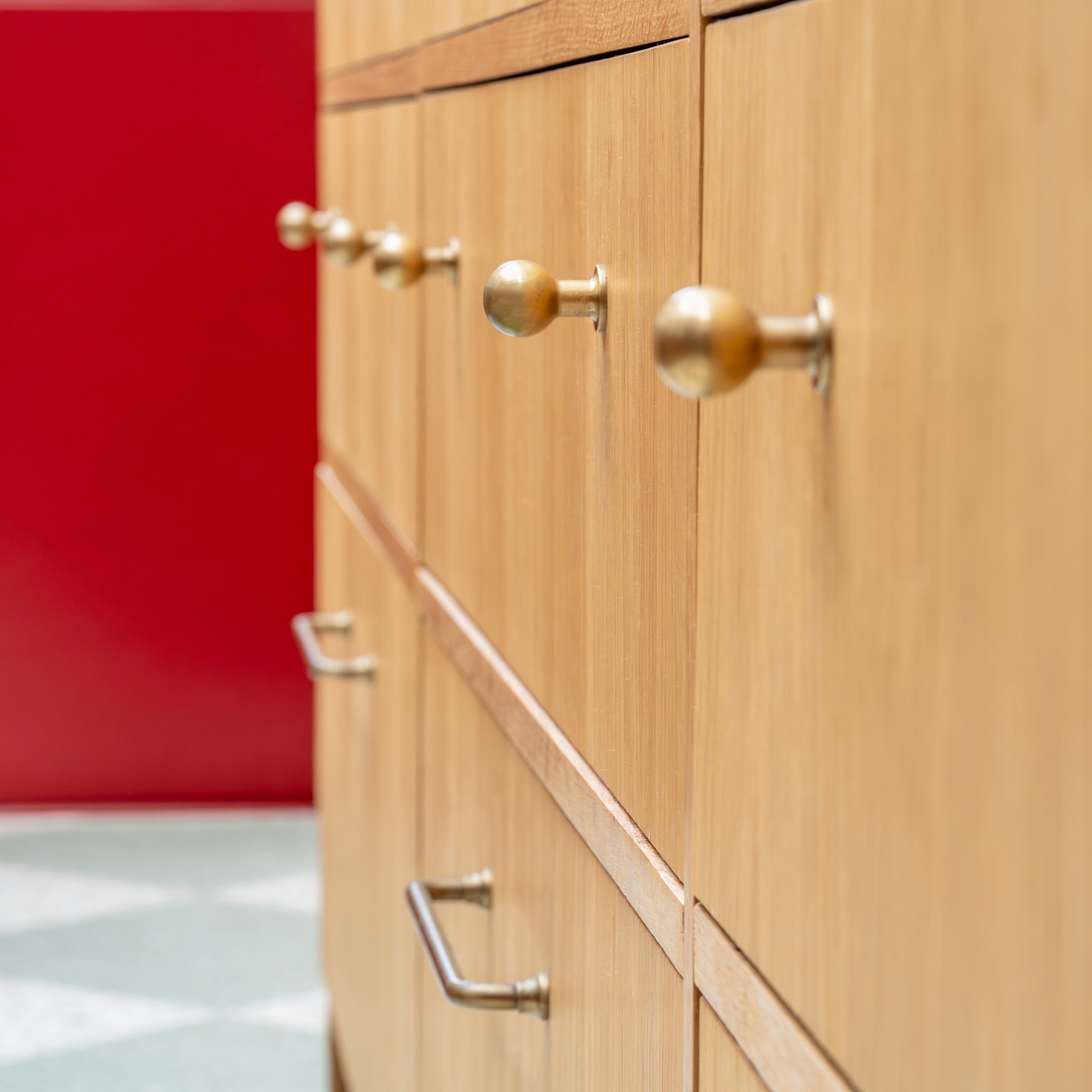 Close-up of a cabinet door featuring the Bayswater Furniture Knob Small in antique brass finish.