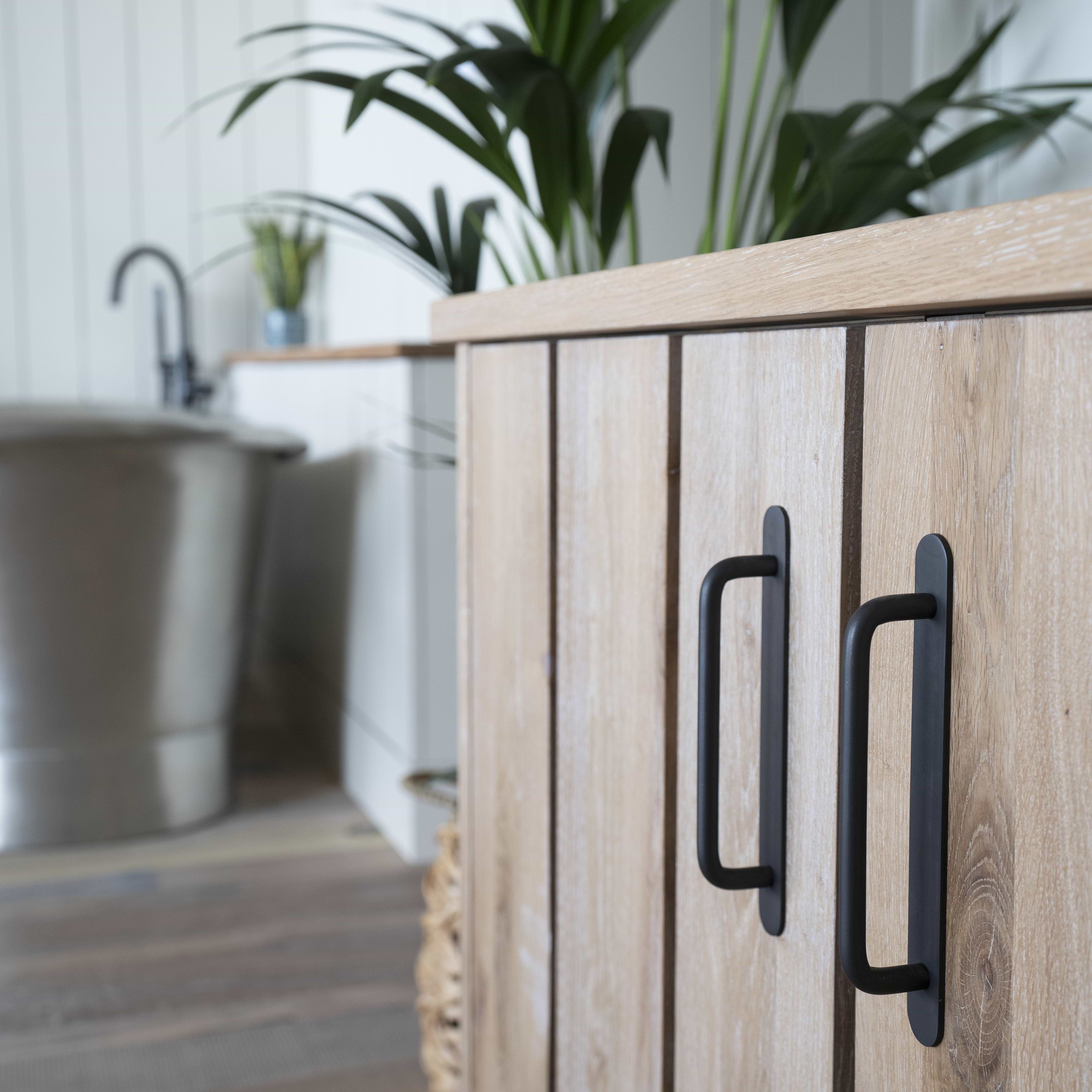 Close-up of a cabinet fitted with the Kilburn Furniture Handle Small in bronze finish.