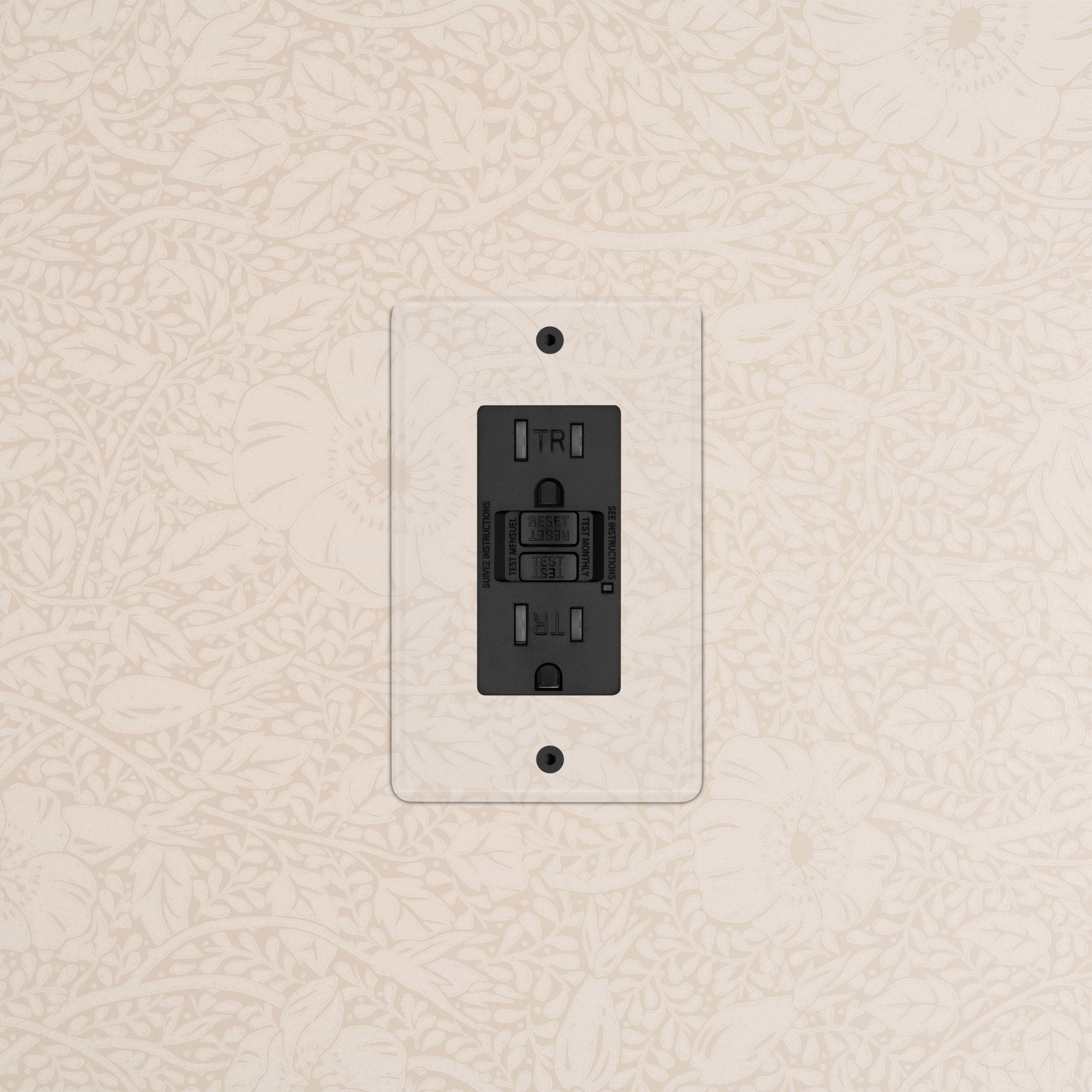 Kew 1G 15A GFCI Outlet in Clear Black, featuring test and reset buttons, installed on a wall.