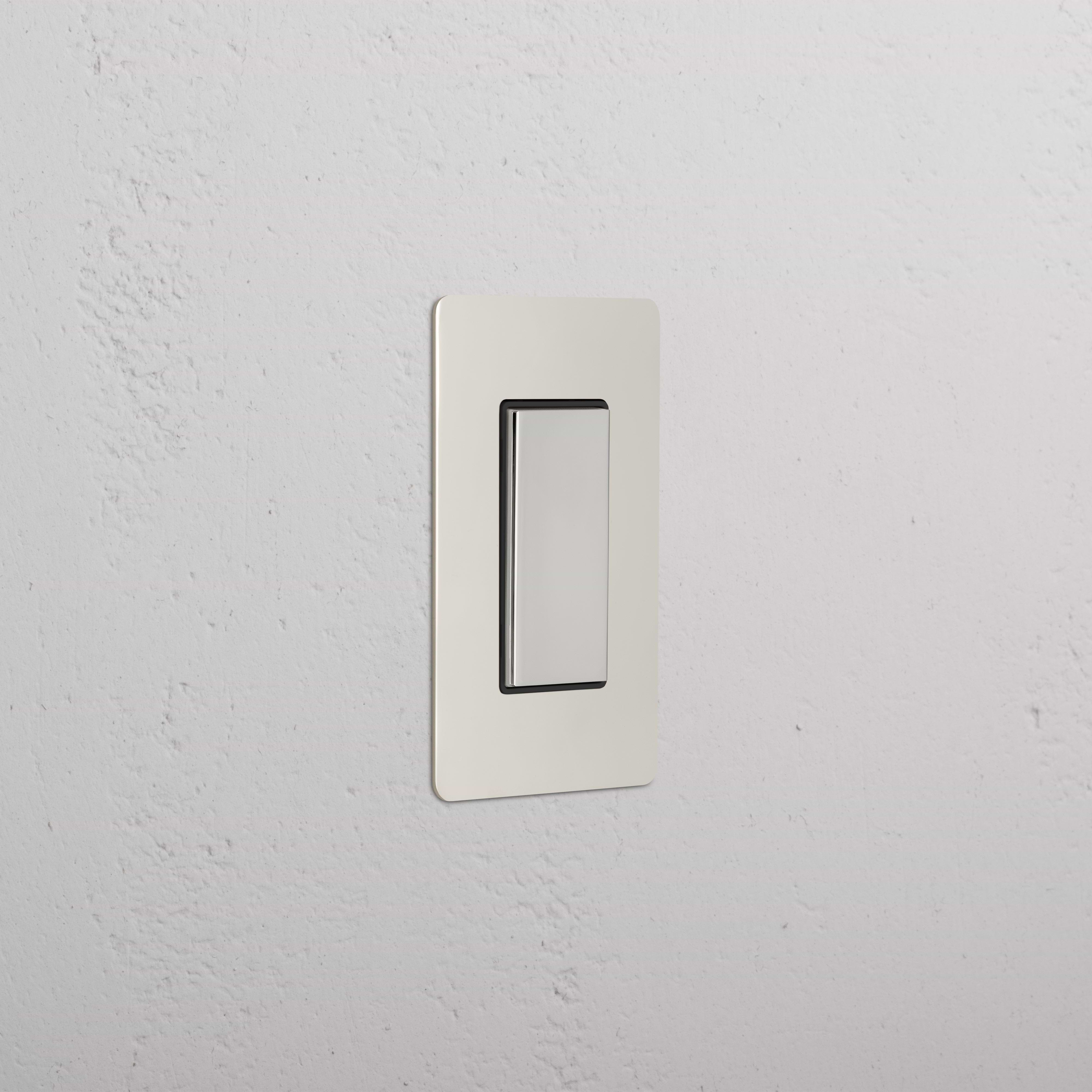 Kew 1G Center Retractive Rocker Switch in polished nickel black, installed on a white textured wall.
