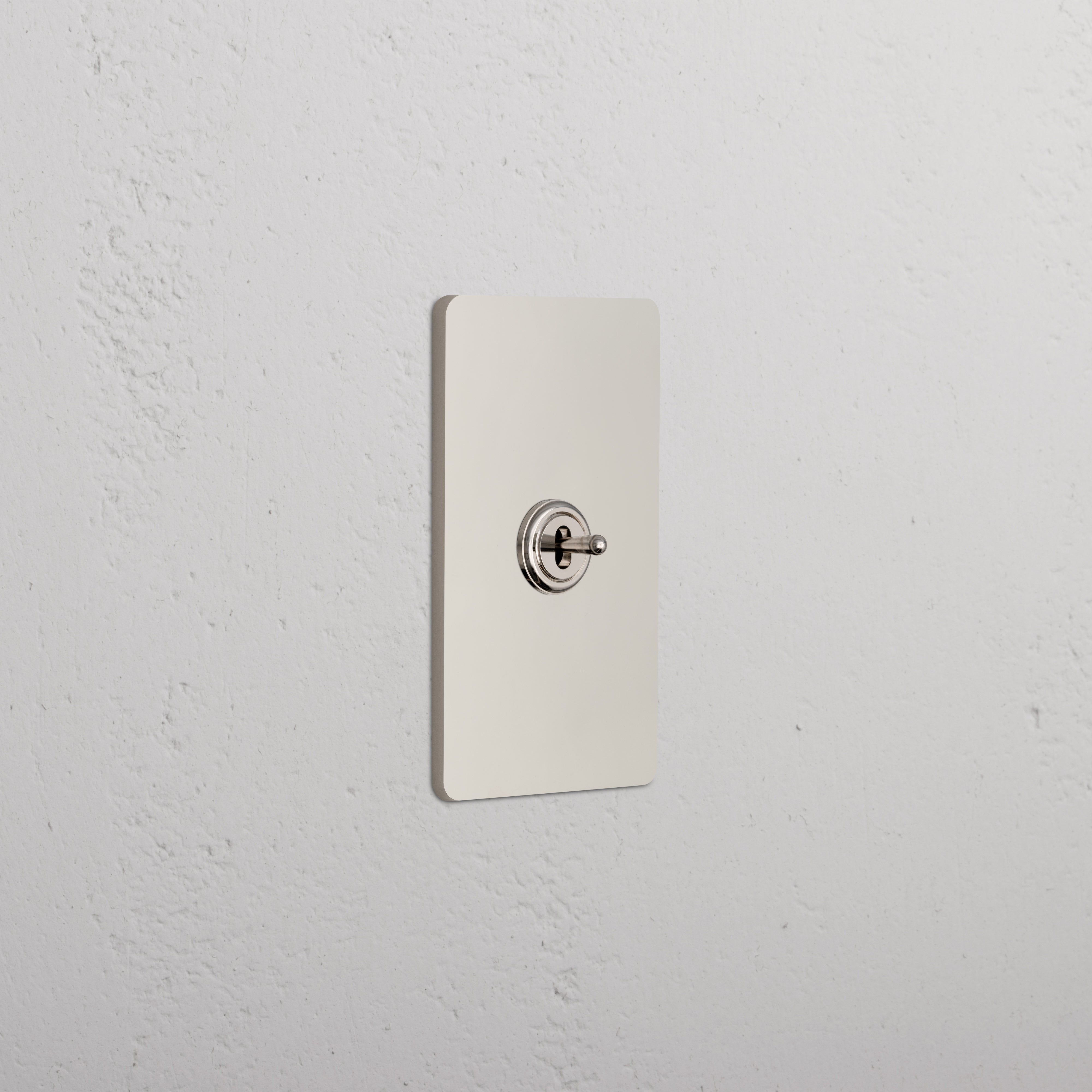 Grove 1G Center Retractive Toggle Switch in polished nickel with single toggle on a white textured wall.