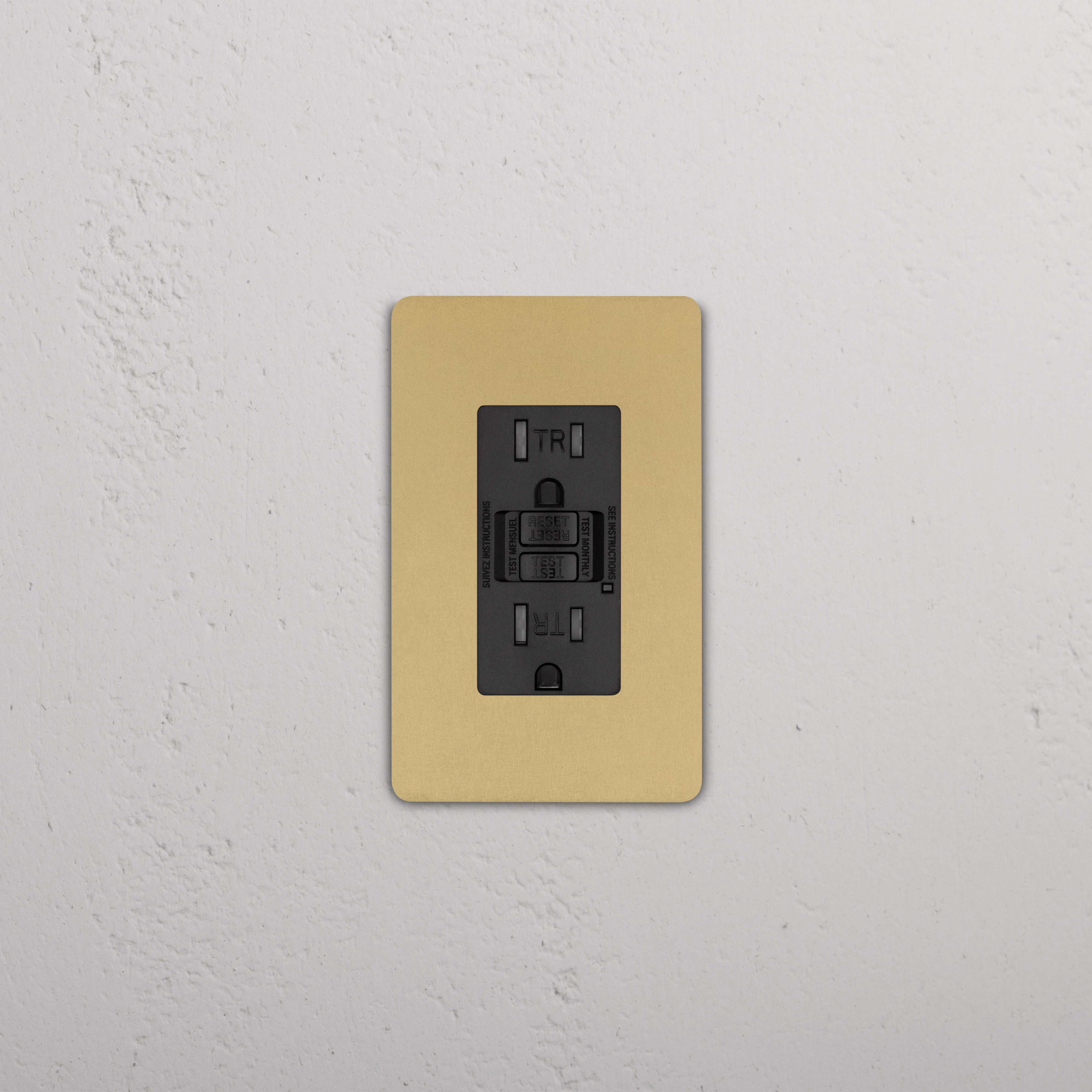 Grove 1G 15A GFCI Outlet in black with antique brass cover plate, installed on a white wall.