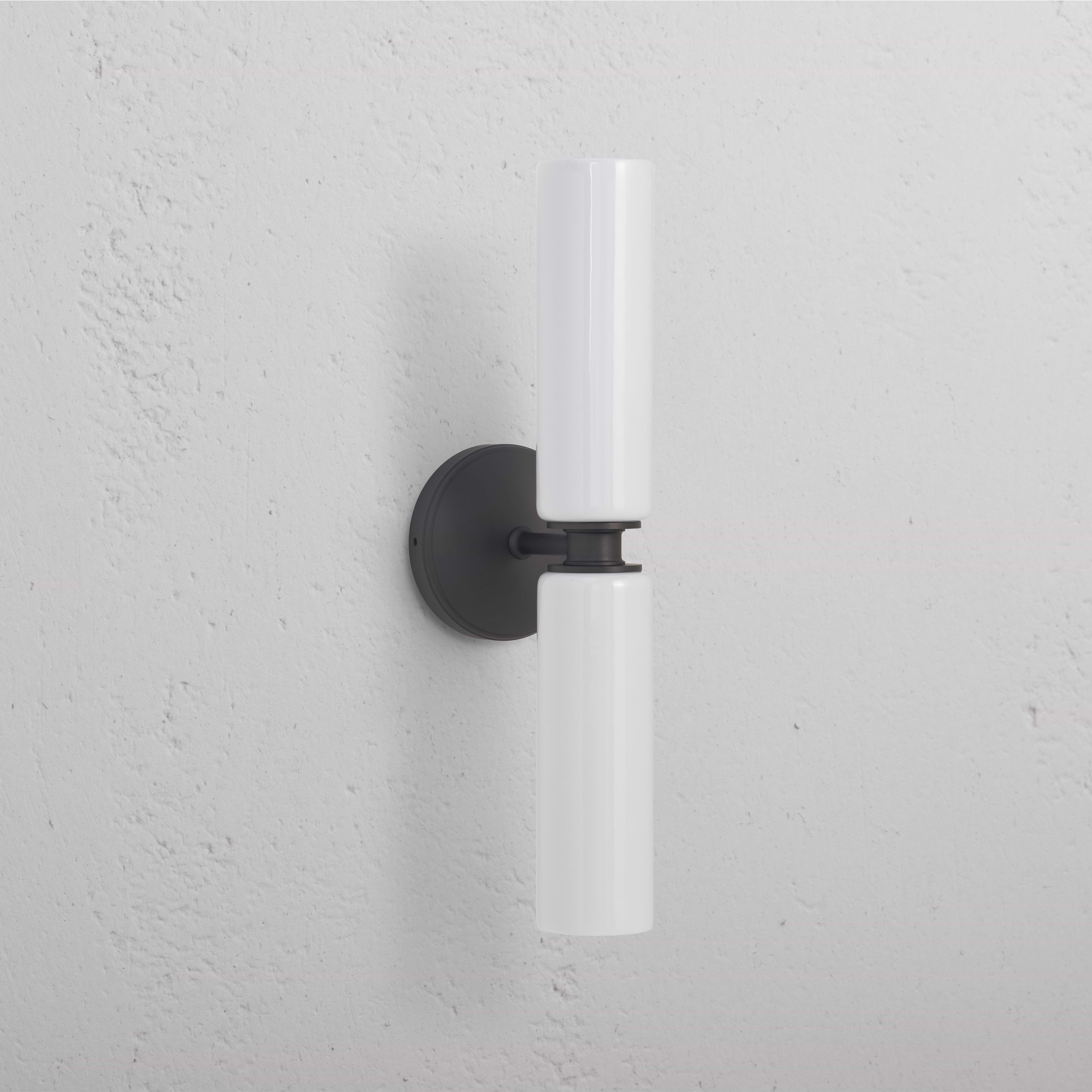 Claremont Medium Wall Light in Fine Porcelain with two white cylinders and a round bronze base, wall-mounted.