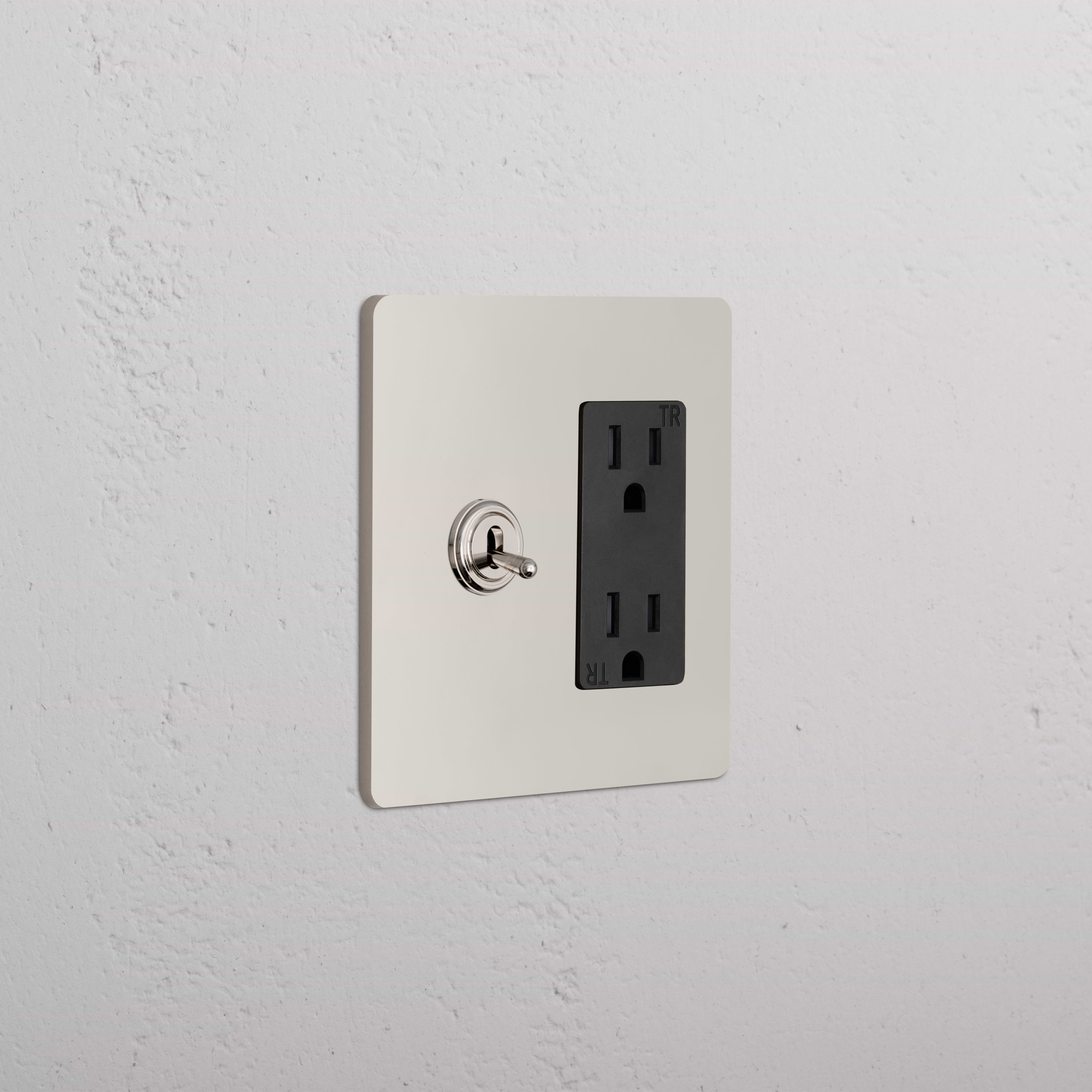 Grove 2G Toggle Switch & Outlet in polished nickel black with toggle switch and black duplex outlet on wall.