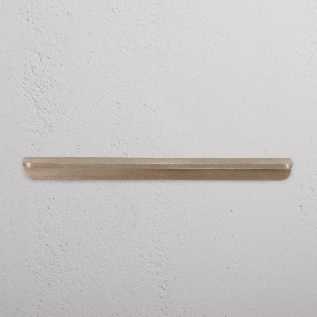 Antique brass Oxford Furniture Handle Medium, mounted on a white surface, shown in close-up view.