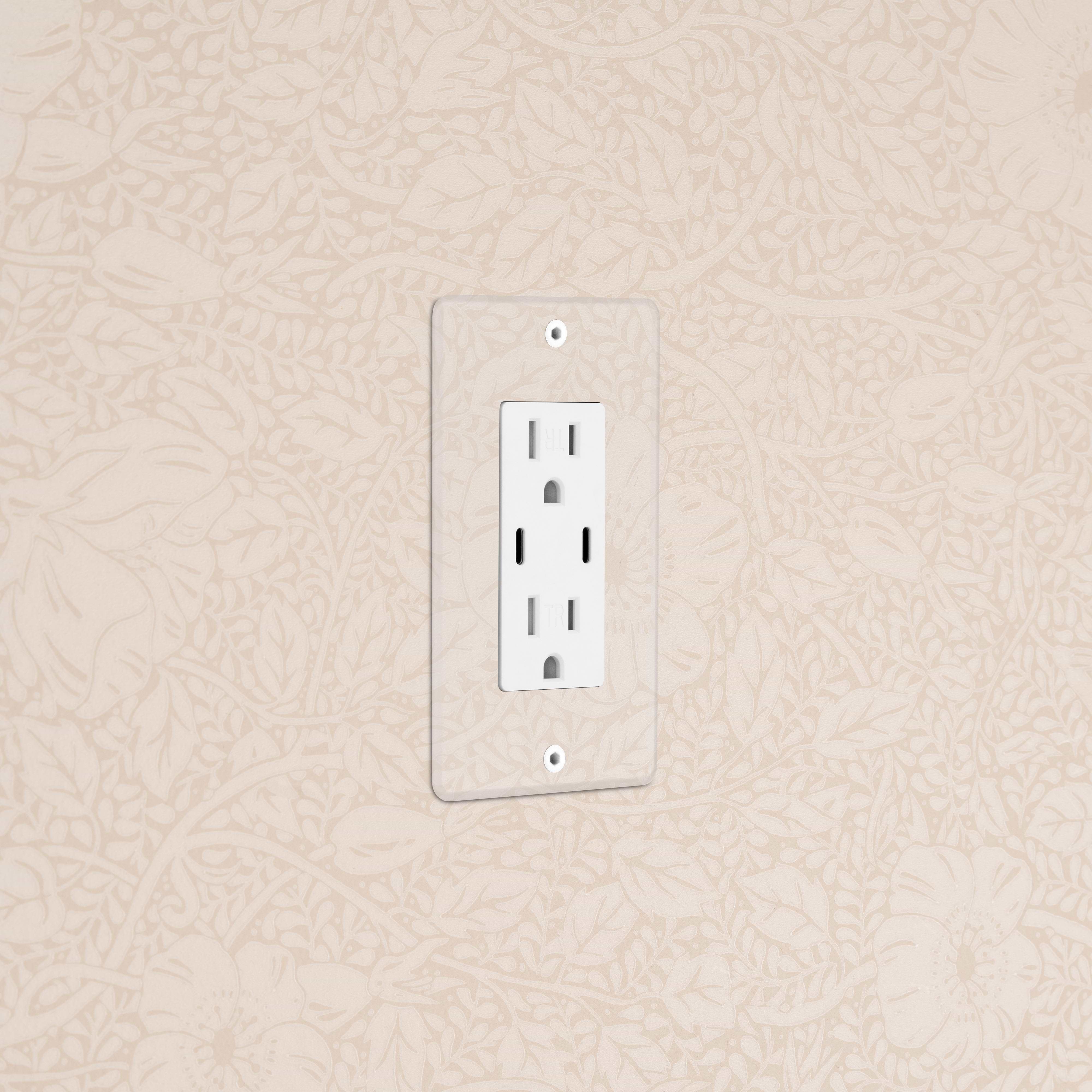 Kew 1G 15A USB Outlet in Clear White with two sockets, mounted on a beige patterned wall.